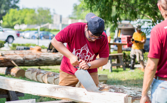 Tradesperson sawing lumber at a training