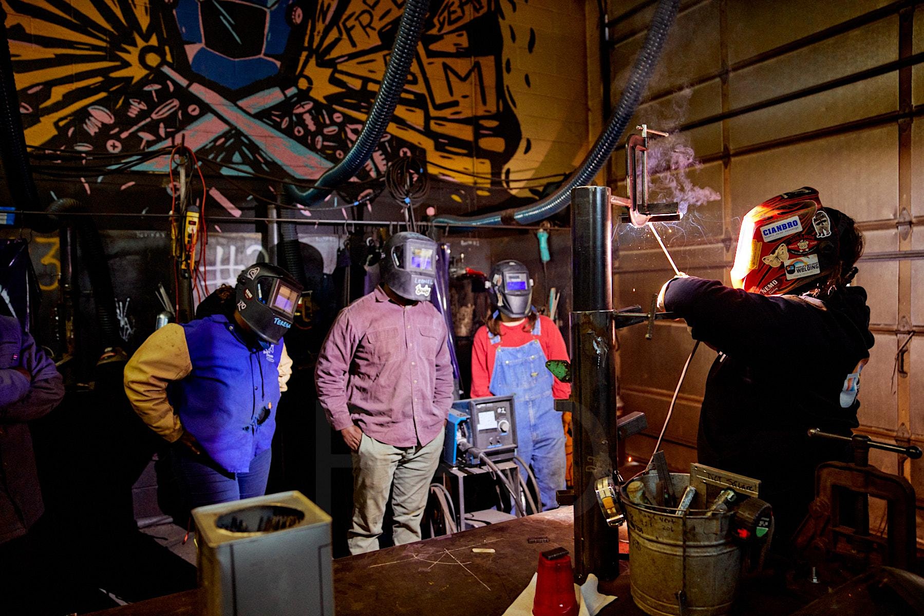 Group of welders watching an active welding demonstration.