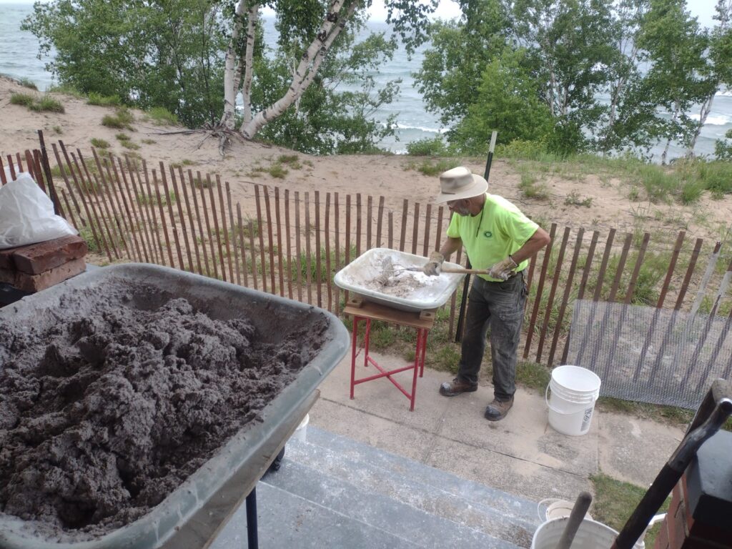 a man mixes materials in a wheelbarrow